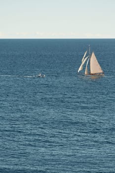 Monaco, lonely vintage sail yacht in sea at sunset, huge sail boat, wealth life of billionaires . High quality photo