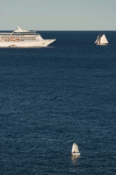 Monaco, vintage sail yacht and huge cruise liner are in sea at sunset, huge motor ship, wealth life of billionaires . High quality photo