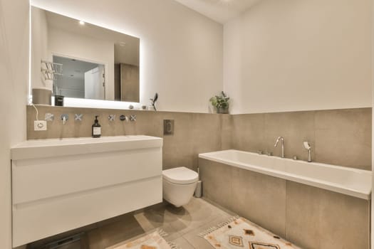 a bathroom with a toilet, sink and bathtub in the background is a mirror on the wall above it