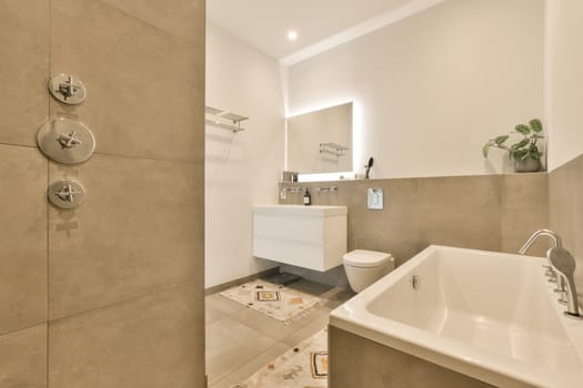 a bathroom with a sink, toilet and mirror in the corner next to the bathtub that has been installed on the wall