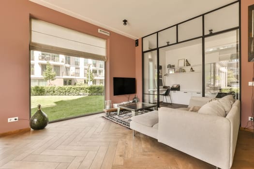 a living room with pink walls and wood flooring in the center of the room, there is a tv on the wall