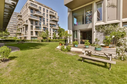 an apartment complex with green grass and trees in the foreground area, as seen from the front lawns