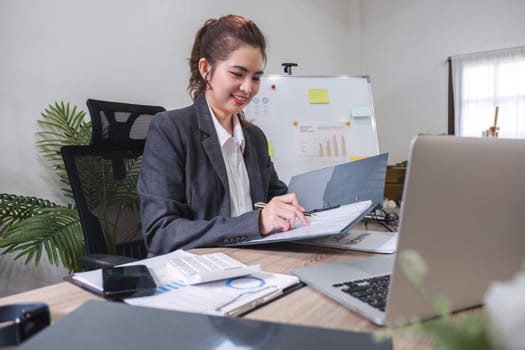 Business woman using calculator for do math finance on wooden desk in office and business working background, tax, accounting, statistics and analytic research concept.