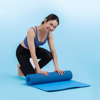 Young attractive asian woman portrait in sportswear with exercising mat. Healthy exercise and workout routine lifestyle concept. Studio shot isolated background. Vigorous