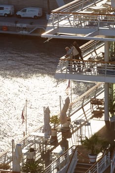 Monaco, Monte Carlo, 18 October 2022: Sunset panorama of port Hercule, moored mega yacht, sun reflection. High quality photo