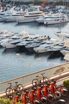 Monaco, Monte Carlo, 18 October 2022: Sunset panorama of port Hercule, moored mega yacht, sun reflection. High quality photo