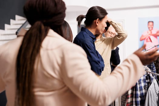 Big crowd of stressed impatient diverse people customers waiting in line at fashion store entrance during seasonal holiday sales. Crowd of anxious shoppers wait for Black Friday deals