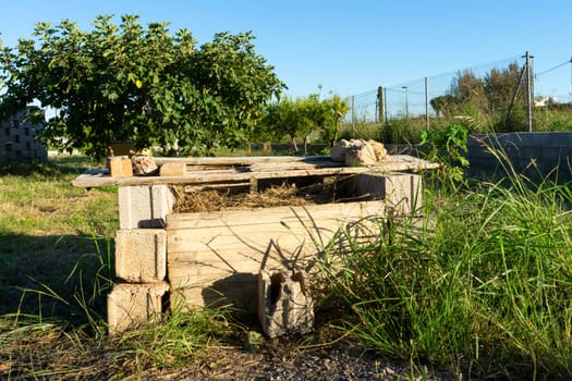 Artisanal composter built rustically, is full of branches and biological remains in rot