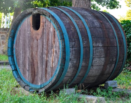Retro concept of winemaking and the good old days. An old wine barrel in front of the wine cellar. The concept of winemaking and organic winemaking. Sustainable winery concept.