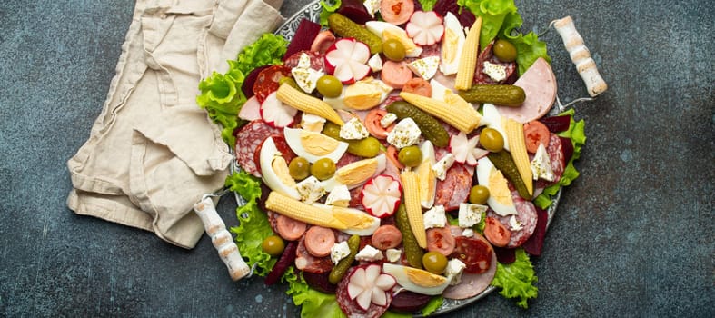 Fiambre, salad of Guatemala, Mexico and Latin America, served on large plate top view. Festive dish for All Saints Day (Day Of The Dead) celebration made of cold cuts, sausages, pickled vegetables.