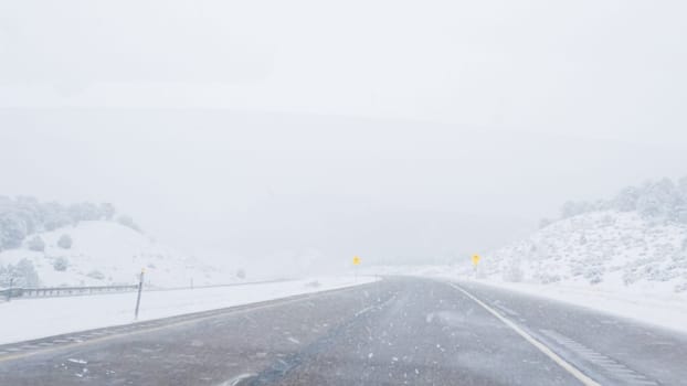 POV-Electric vehicle is captured deftly navigating the I-70 highway during a winter storm in Western Colorado.