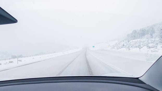 POV-Electric vehicle is captured deftly navigating the I-70 highway during a winter storm in Western Colorado.