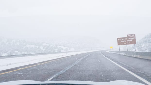 POV-Electric vehicle is captured deftly navigating the I-70 highway during a winter storm in Western Colorado.