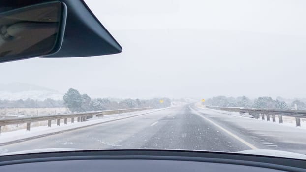 POV-Electric vehicle is captured deftly navigating the I-70 highway during a winter storm in Western Colorado.