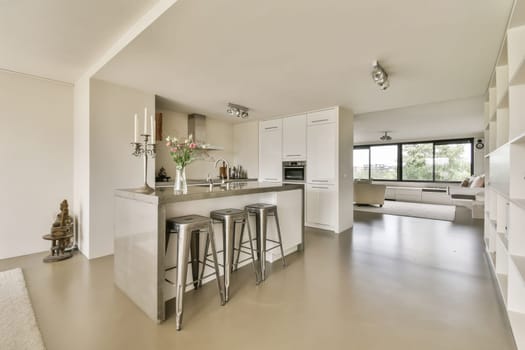 a kitchen and dining area in a house with white cabinets, counters, stools and bar stools