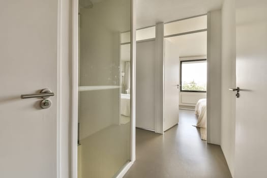 a bathroom with a shower and toilet in the corner, as seen through an open door on the right side