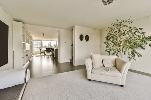 an empty living room with white carpet and large plant in the center of the room, there is a tv on the wall