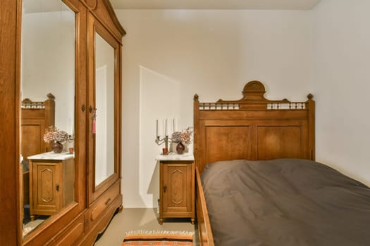 a bedroom with a bed, dresser and mirror on the wall above it that is in front of the door