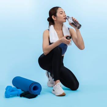 Athletic and sporty asian woman resting and drink water after intensive cardio workout training. Healthy exercising and fit body care lifestyle pursuit in studio shot isolated background. Vigorous