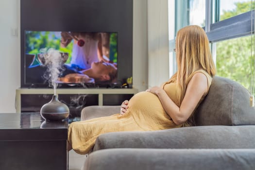 A blissful pregnant woman immerses in relaxation, savoring the soothing aroma from a diffuser while indulging in a calming TV video, embracing tranquility during her pregnant journey.