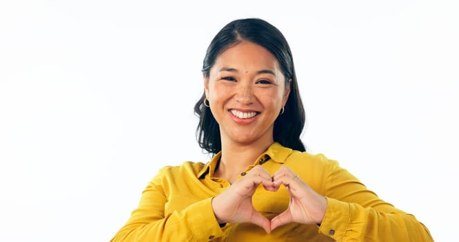 Portrait, love and heart hands with a young asian woman isolated on a white background in studio for health or wellness. Face, romance and satisfaction with a happy young person on valentines day.
