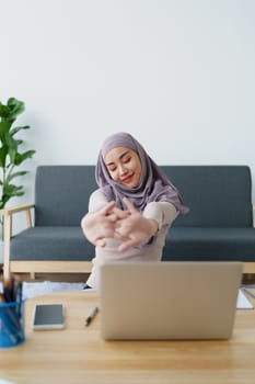 Muslim undergraduate students relax their muscles after taking online e-learning via computer system