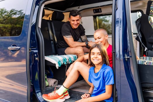 family resting in camper van after doing sports in nature, concept of family outdoor activities and healthy lifestyle