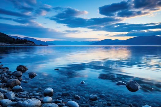 Sea, pebble beach and mountains at dusk. Beautiful seascape.