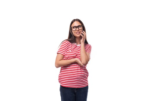 young smiling energetic brunette woman with glasses dressed in a striped t-shirt on a white background with copy space.