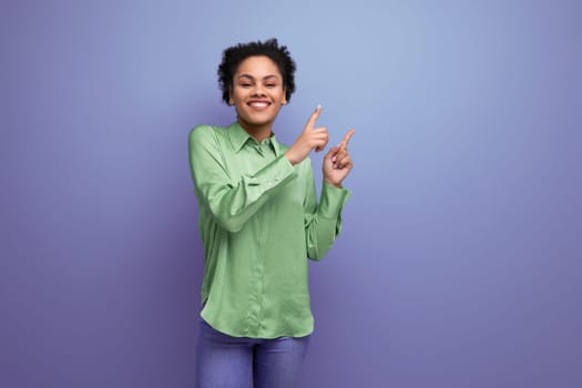 young cheerful positive hispanic brunette lady dressed in a green stylish blouse smiling on the background with copy space.