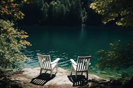 Two chairs for relaxing on the bank of a calm river in a pine forest. Camping, recreation.