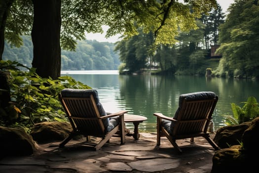 Two chairs for relaxing on the bank of a calm river in the forest. Camping, recreation.