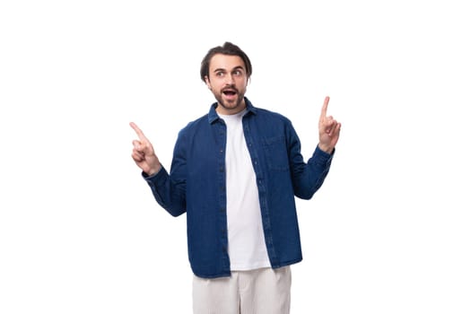 young well-groomed brunette guy in a casual blue shirt on a white coin with copy space.