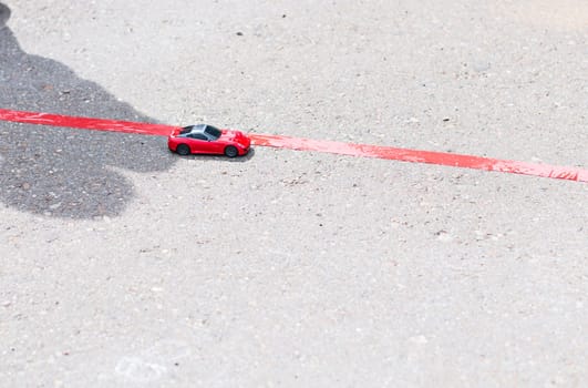 toy red car outdoors. small car on the road