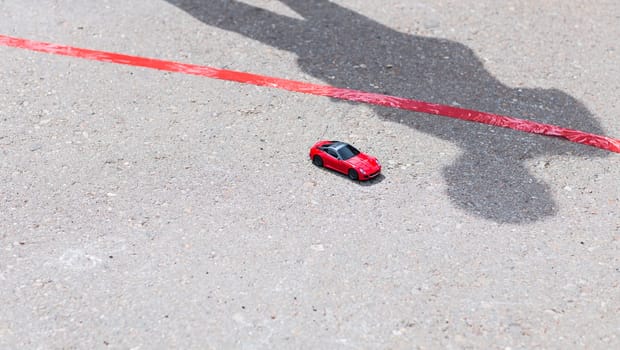 toy red car outdoors. small car on the road