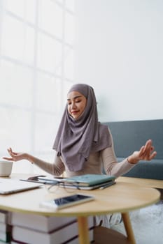 Muslim female employee Meditate while working in the office