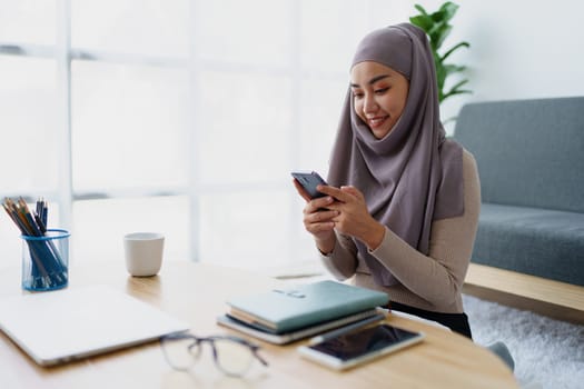 Muslim undergraduate student using mobile phone to contact friends