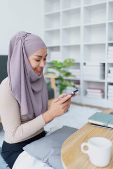 Muslim undergraduate student using mobile phone to contact friends