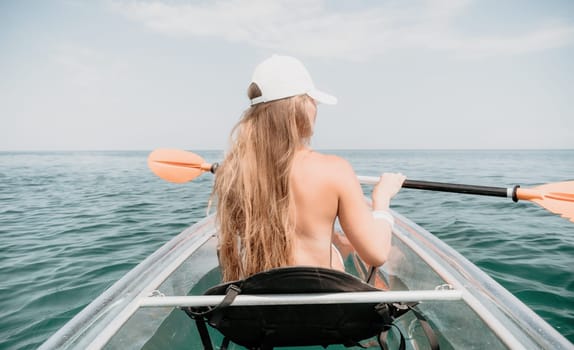 Woman in kayak back view. Happy young woman with long hair floating in transparent kayak on the crystal clear sea. Summer holiday vacation and cheerful female people having fun on the boat.