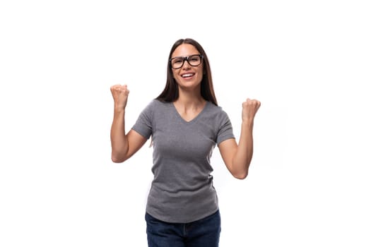 young promoter woman in glasses dressed in a gray t-shirt on a white background with copy space.