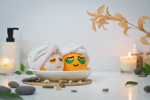 Oranges in towels looking like in bath or Onsen. Spa treatment and self care concept.