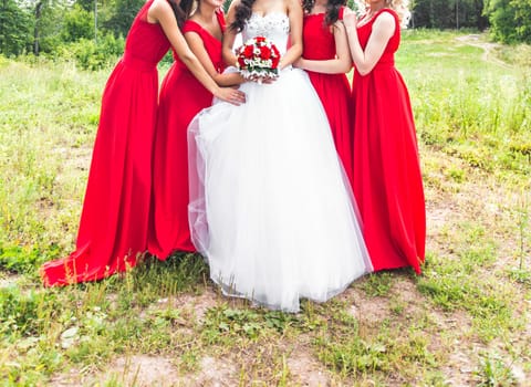 Bride with bridesmaids on the park on the wedding day