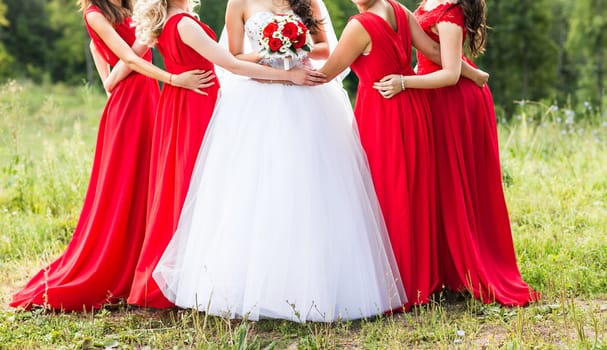 Bride with bridesmaids on the park on the wedding day