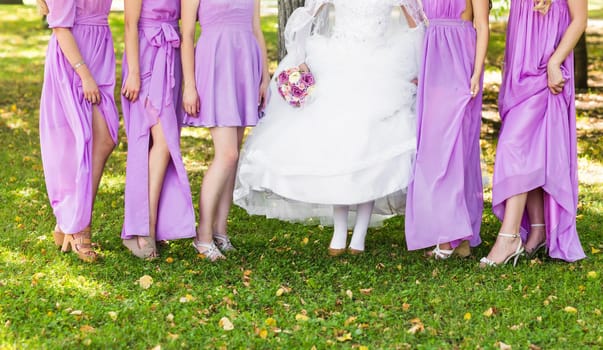 Bride and bridesmaids show off their shoes at wedding