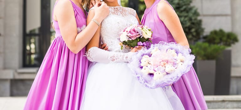 Bride with bridesmaids on the park on the wedding day