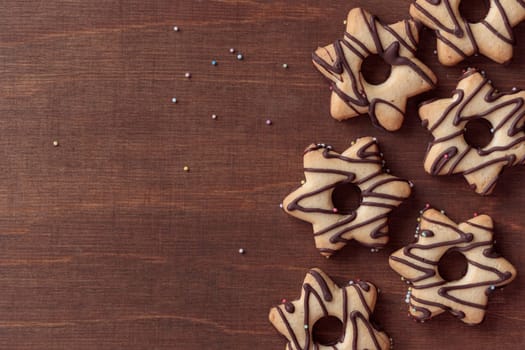 Freshly baked homemade star-shaped cookie with chocolate on the wooden table with a copy space, horizontal banner