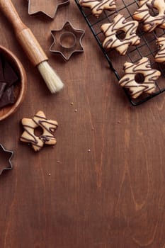 Freshly baked homemade star-shaped cookie with chocolate on the grid on the wooden table with a copy space, vertical