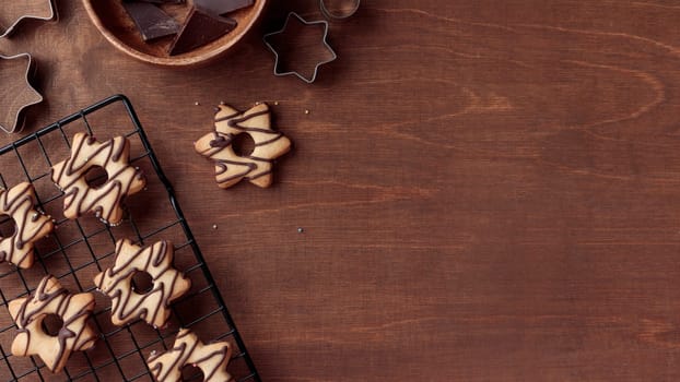 Freshly baked homemade star-shaped cookie with chocolate on the grid on the wooden table with a copy space, horizontal banner