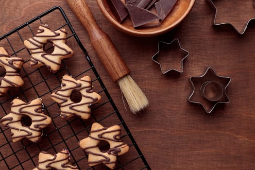 Freshly baked homemade star-shaped cookie with chocolate on the grid on the wooden table with a copy space, horizontal banner