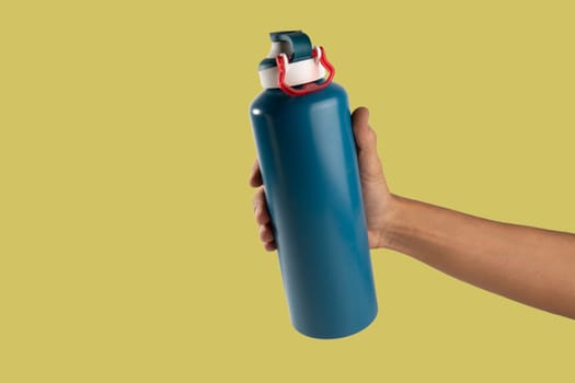 Black male holding thermo bottle canteen on light yellow